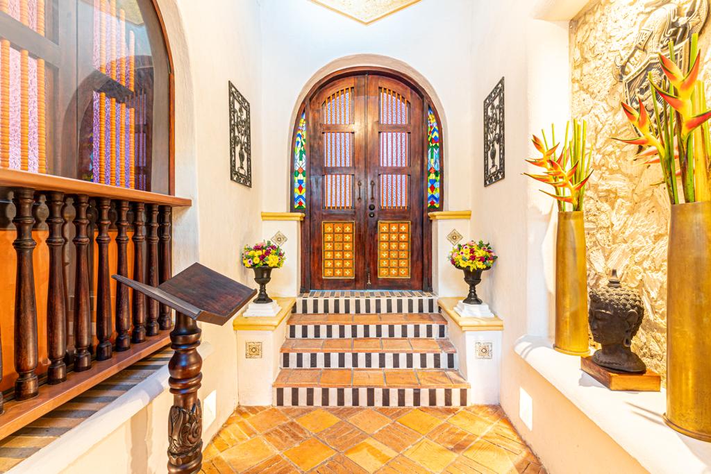 Lobby con puerta colonial y vitrales